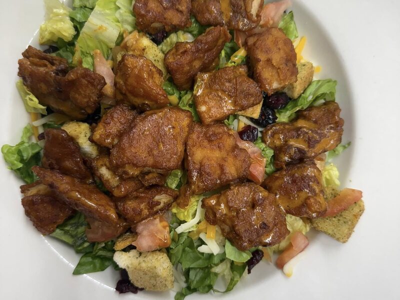 Seasoned chicken served over fresh greens
